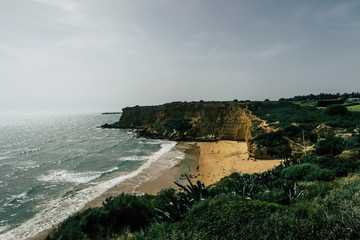 Fototapeta na wymiar Beautiful spanish coastline with cliffs: Beach, Sea, Waves with white crest during sunset