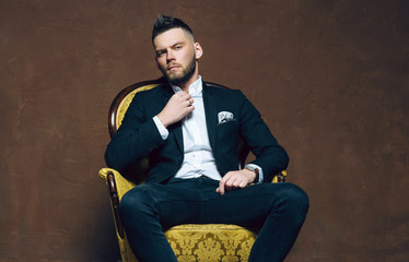 Young handsome man posing for a fashion shoot in a studio. Fashion as a lifestyle. Man wearing a...