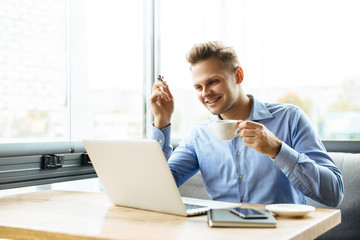 Obraz premium Young businessman working on a plan of Internet project on the laptop. Man discusses business matters by phone. Working computer for internet research. Digital marketing. Development