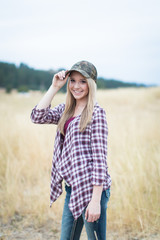 Beautiful young blond smiling with camouflage hat