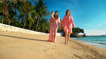 The concept of the strange adventures of people. Happy lesbian couple with babe walking on...
