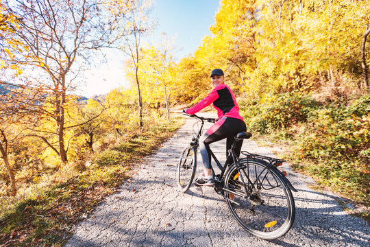 Woman on bicycle at autumn day wearing sportswear