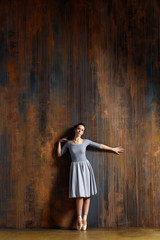 Fototapeta premium Young beautiful ballerina is posing in studio