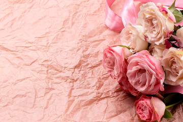 A bouquet of beautiful roses on a pink craft background with space for text