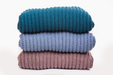 Fototapeta na wymiar A stack of warm knitted sweaters