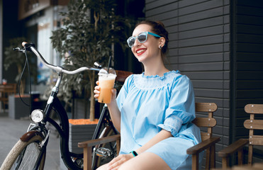 Young attractive woman riding through the park after work. Beautiful lady cycling during sunset. Bike as a trendy transport. Healthy outdoors activity on a warm summer day. Bicycle trend in the city.