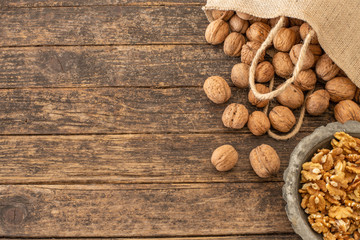 Many walnuts on the rustic table and in the shopping bag