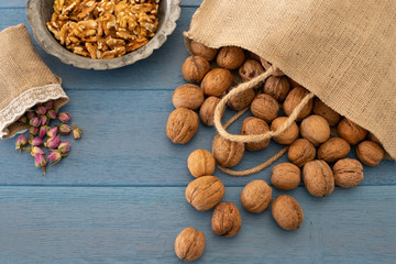 Many walnuts on the rustic table and in the shopping bag