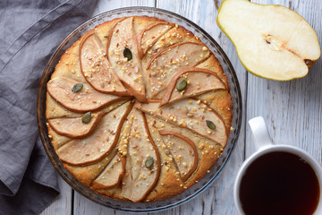 gorgeous pie with pears in a glass container on wooden background