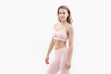 Fototapeta premium Sports blonde girl in red training clothes in the studio on a white background.
