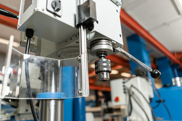 Drilling machine. New Industrial Iron drill in workshop interior. Tool store or exposition stand.