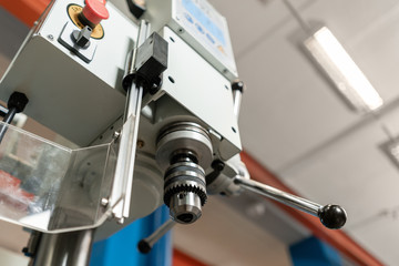 Drilling machine. New Industrial Iron drill in workshop interior. Tool store or exposition stand.