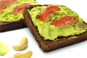 sandwich with avocado on a white plate nuts