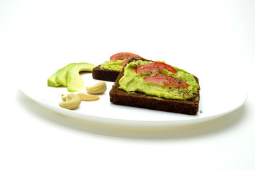 sandwich with avocado on a white plate nuts
