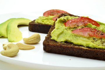 sandwich with avocado on a white plate nuts