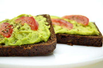 sandwich with avocado on a white plate nuts