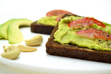 sandwich with avocado on a white plate nuts