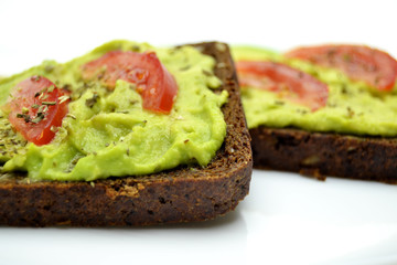 sandwich with avocado on a white plate nuts