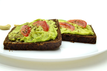 sandwich with avocado on a white plate nuts