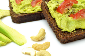 sandwich with avocado on a white plate nuts