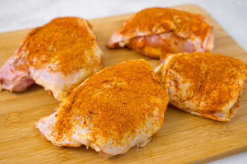 Raw Chicken Thighs Seasoned with Turmeric and Paprika