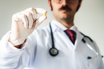 Portrait of male doctor giving you a pill.