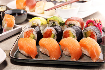 close up of sashimi sushi set with chopsticks and soy - sushi roll with salmon and sushi roll with smoked eel