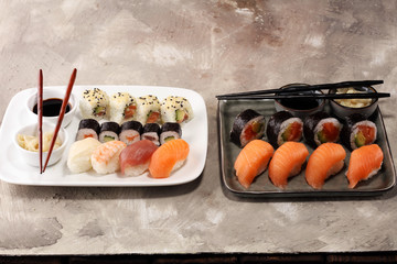close up of sashimi sushi set with chopsticks and soy - sushi roll with salmon and sushi roll with smoked eel