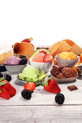 Set of ice cream scoops of different colors and flavours with berries, chocolate and fruits.