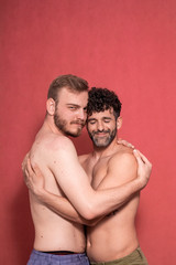 sexy gay couple, hugging each other. eyes closed, and looking to camera, calm.