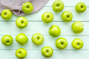 Fototapeta na wymiar food pattern with green apples on light wooden background top view