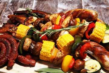 Assorted delicious grilled meat and skewer with vegetable on rustic table