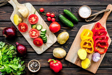 Fresh food ingredients for vegetarian kitchen on wooden background top view