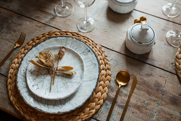 White plate and golden fork with a spoon, appliances for frying, wedding decoration. Christmas or tanksgiving dinner. From above