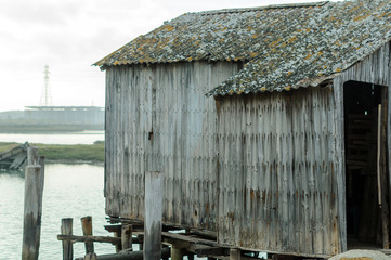 Fototapeta na wymiar Cobertizo de madera abandonado en orilla de río 03