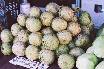 Fresh green artichokes for sale at a farmers market stall