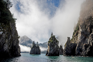 A covering of fog creates strange shapes around boulders in Resurrection Bay, Alaska.