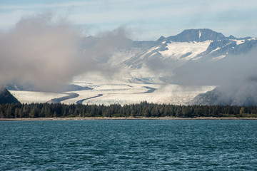 Glaciers and fog lie around the mountains in Seward Bay, Alaska.