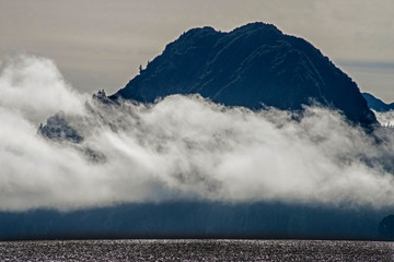 A covering of fog creates strange shapes around boulders in Resurrection Bay, Alaska.