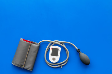 pulsimeter on the desk of the doctor for diagnostics of cardiac disease on blue background top view space for text