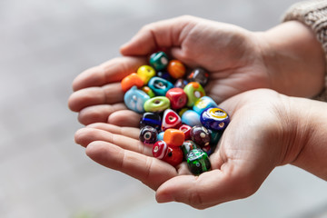 Palm of Hand Displaying Outstanding Original Handmade Glass Beads in Miscellaneous Varied Colors. 