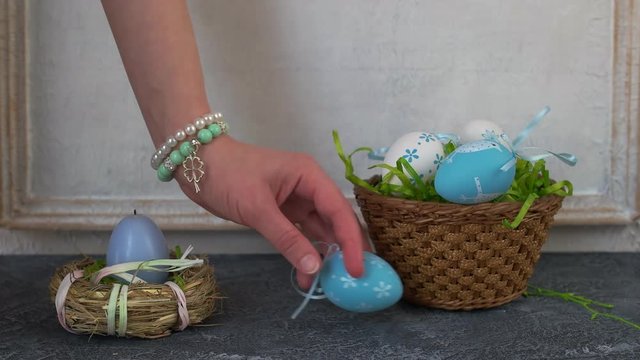 Painted ester eggs in a basket. White vintage wall in background. Copy space.