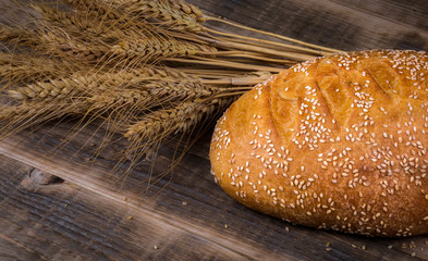 Fresh fragrant bread on a wooden table. Homemade hot pastry with.