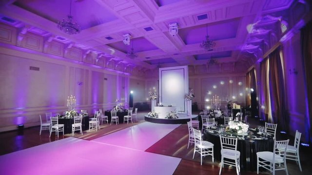 Luxury wedding restaurant, decorated banquet room wide angle camera shooting. Served table with a black tablecloth
