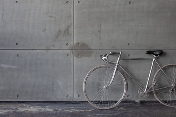Fototapeta na wymiar Bicycle on a cement wall. Hipster background