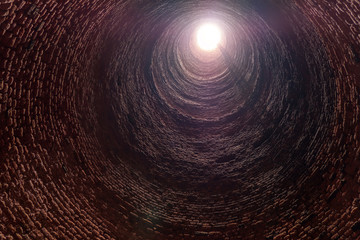 Inside old red brick tube shaft with ladder