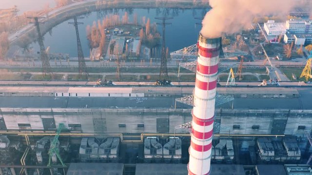 Aerial look-down view of smoking chimneys of CHP plant (coal-fired power station) at sunset