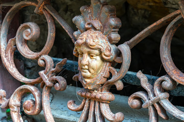 Window grille with human head as decoration