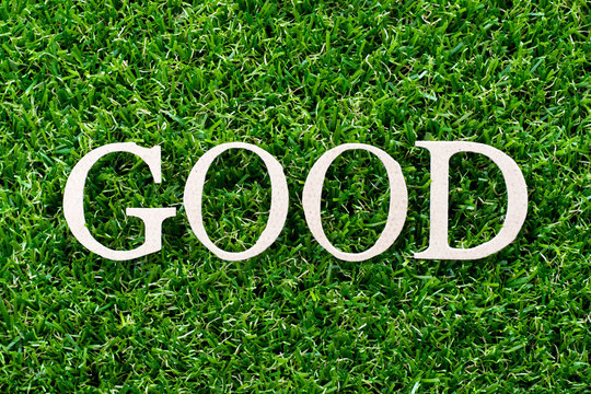Wood letter in word good on artificial green grass background