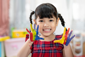 Asian cute kid girl showing hand with colorful painting. creative girl with fun.
